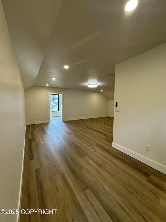 bonus room with vaulted ceiling, baseboards, and wood finished floors