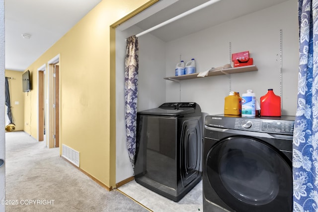 washroom featuring carpet floors, laundry area, visible vents, and washer and clothes dryer