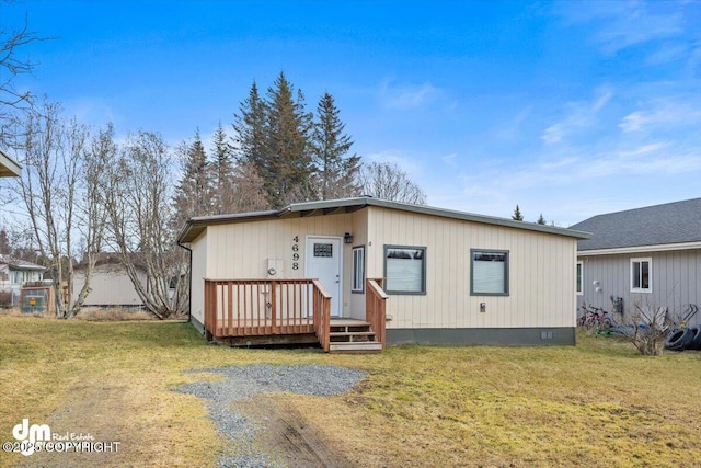 view of front of property featuring crawl space, a wooden deck, and a front yard