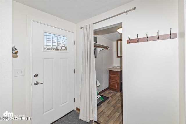 mudroom with a textured ceiling and wood finished floors