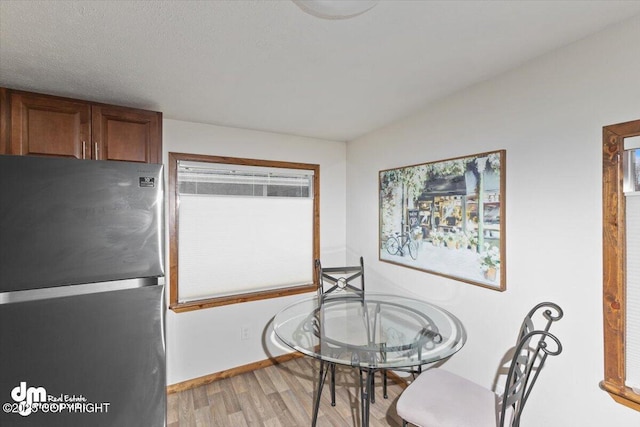 dining room featuring light wood-type flooring and baseboards