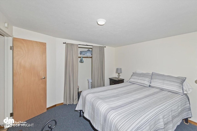 carpeted bedroom featuring baseboards and a textured ceiling