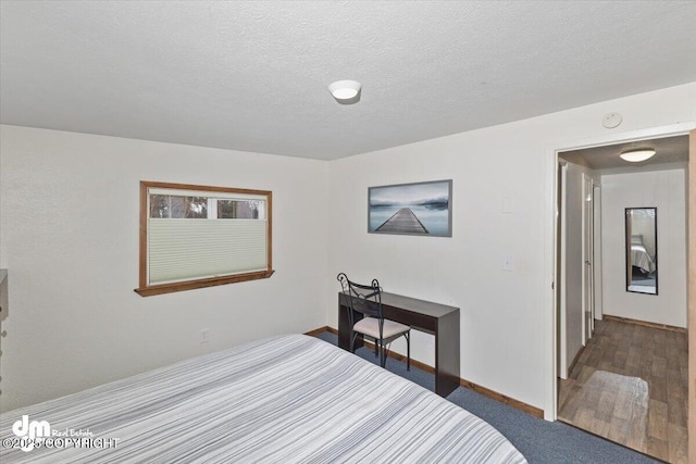 carpeted bedroom featuring baseboards and a textured ceiling