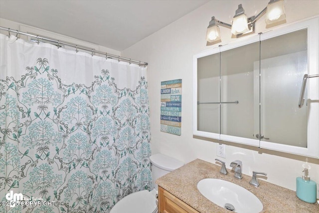 bathroom featuring curtained shower, vanity, and toilet