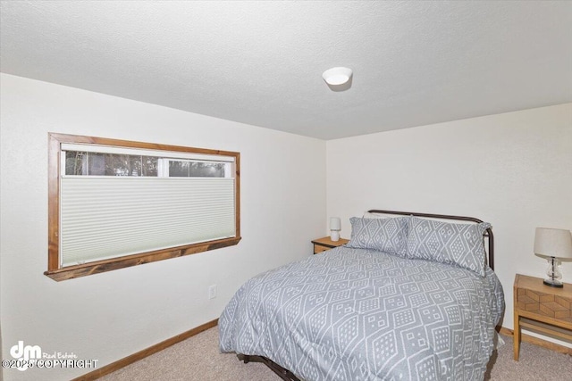 bedroom featuring a textured ceiling, carpet, and baseboards