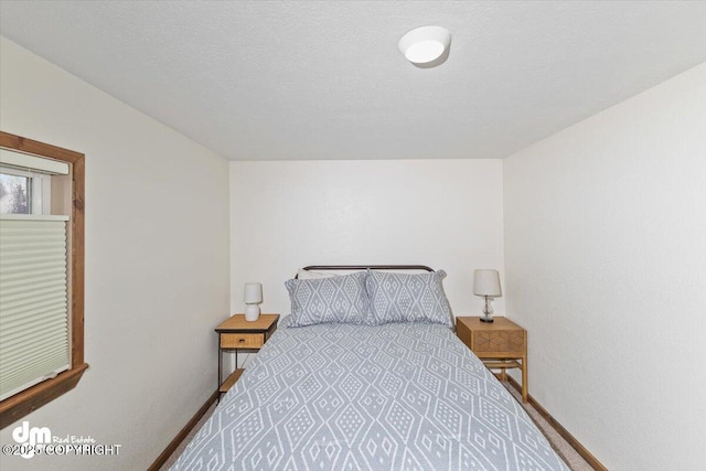 bedroom with a textured ceiling and baseboards