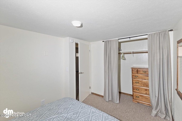 bedroom with a closet, carpet flooring, and a textured ceiling