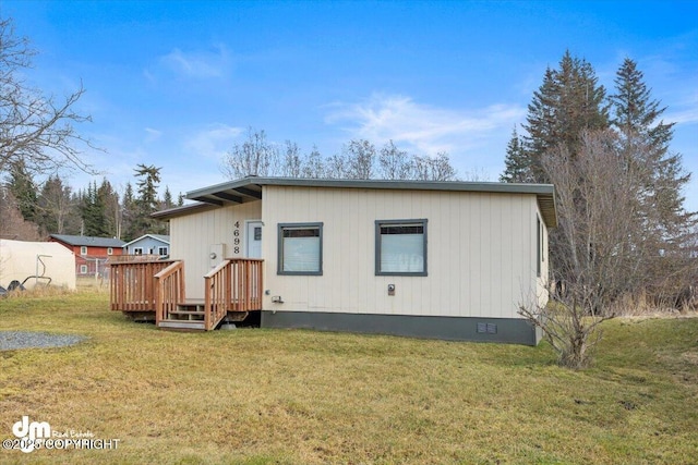 rear view of property featuring a yard and crawl space