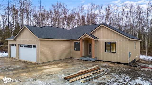 view of front facade with a garage and roof with shingles