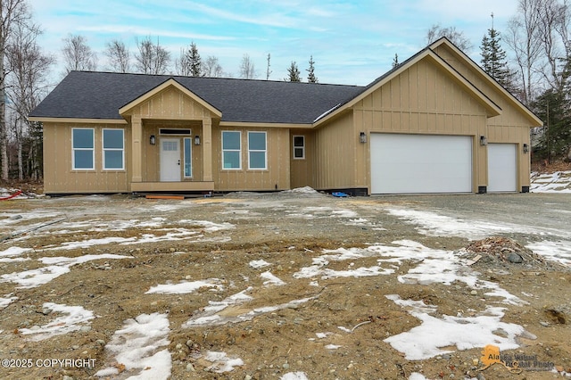 view of front facade with a shingled roof and an attached garage