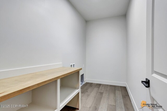 laundry area with laundry area, baseboards, washer hookup, and wood finished floors