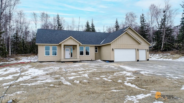 view of front of house featuring driveway, roof with shingles, and an attached garage