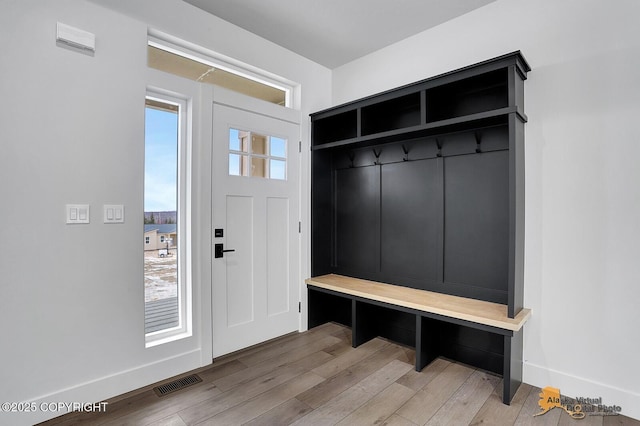 mudroom with a healthy amount of sunlight, visible vents, baseboards, and wood finished floors