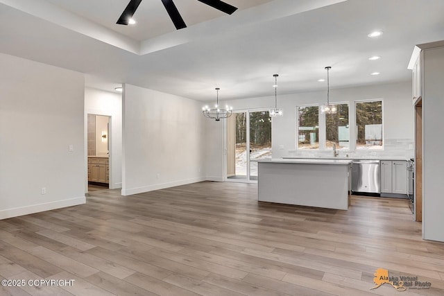 kitchen with tasteful backsplash, light countertops, light wood-style flooring, and stainless steel dishwasher