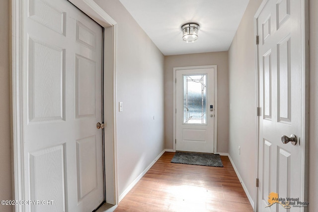 doorway with light wood-style floors and baseboards