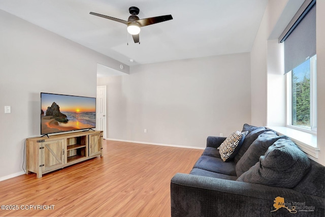 living room with ceiling fan, light wood-style flooring, and baseboards