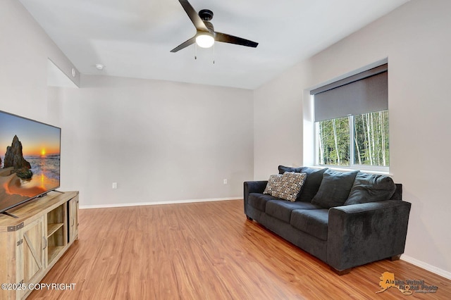 living area featuring light wood-type flooring, ceiling fan, and baseboards