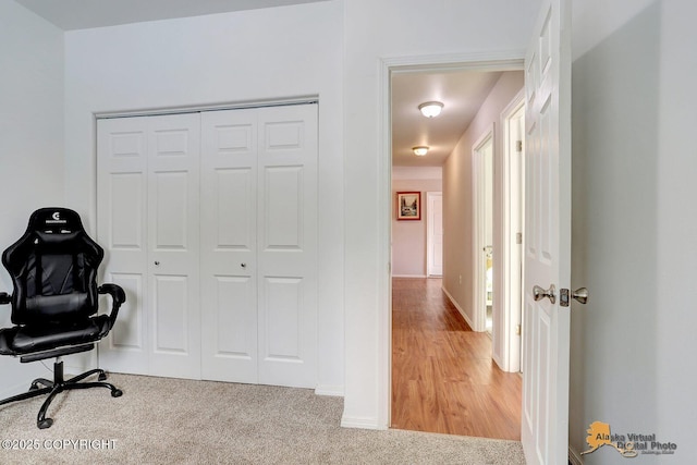 office area featuring light carpet and baseboards