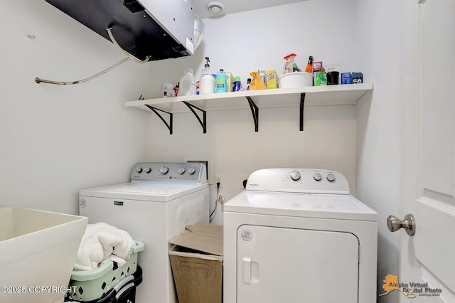 clothes washing area featuring washing machine and dryer, laundry area, and a sink