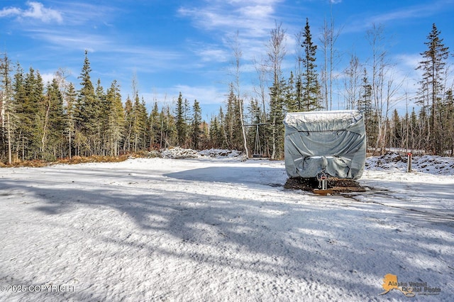 yard covered in snow with a forest view