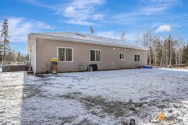 view of snow covered back of property