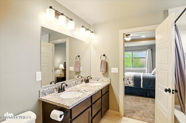 ensuite bathroom featuring toilet, a ceiling fan, and double vanity