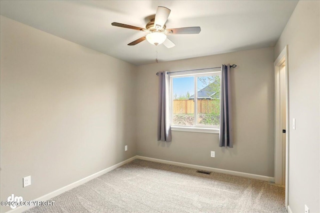 empty room with baseboards, light colored carpet, and a ceiling fan