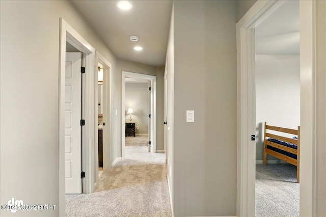 hallway featuring carpet flooring, recessed lighting, and baseboards