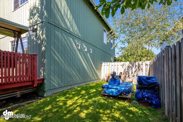 view of side of property featuring a fenced backyard and a lawn