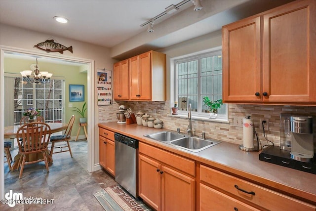 kitchen with a chandelier, a sink, light countertops, backsplash, and dishwasher