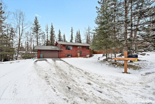 snow covered property with a garage