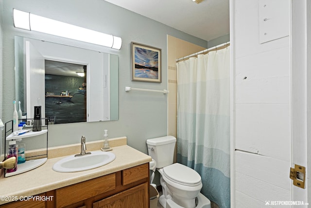 full bathroom featuring toilet, vanity, and a shower with curtain