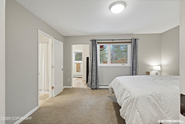 carpeted bedroom with a baseboard radiator, baseboards, and ensuite bathroom