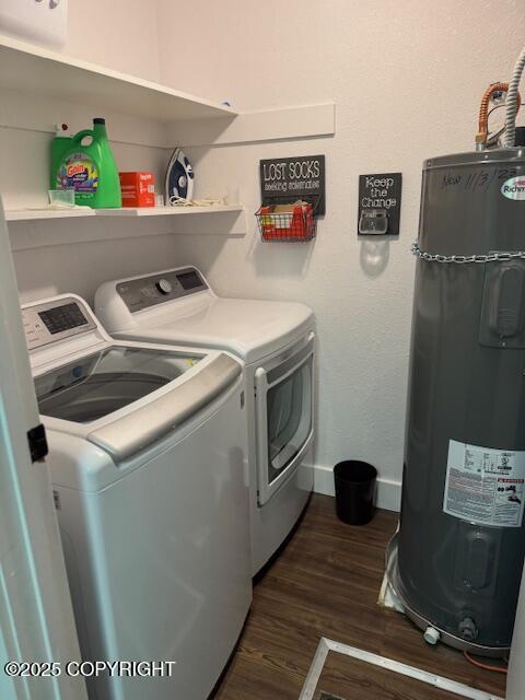 washroom featuring water heater, laundry area, dark wood-type flooring, and washing machine and clothes dryer