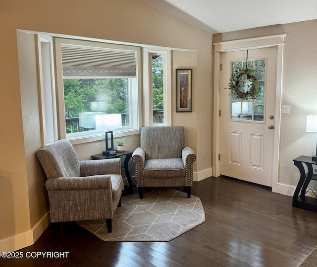 living area with dark wood-style floors, baseboards, and vaulted ceiling