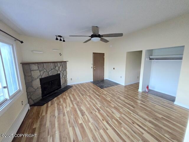 unfurnished living room featuring plenty of natural light, a fireplace, and wood finished floors