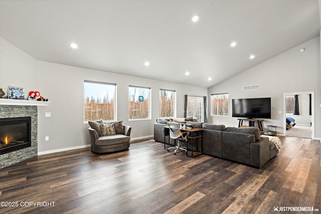 living area featuring dark wood-style flooring, a glass covered fireplace, visible vents, and recessed lighting