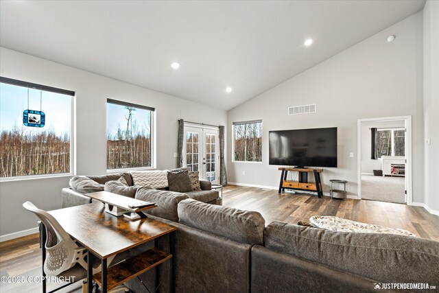 living area with high vaulted ceiling, recessed lighting, wood finished floors, visible vents, and french doors