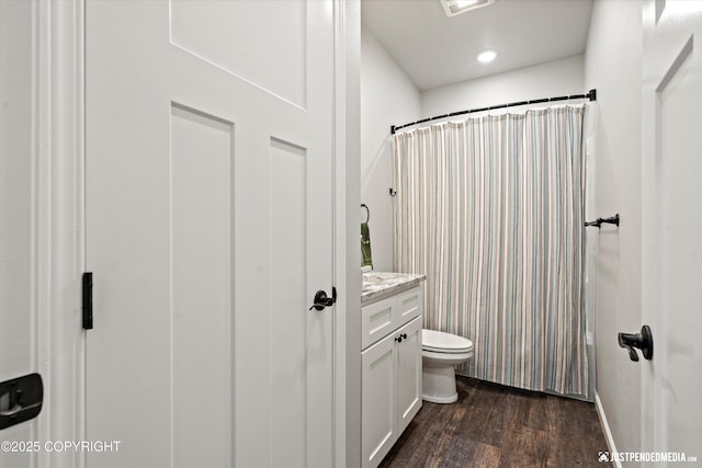 bathroom featuring baseboards, toilet, a shower with curtain, wood finished floors, and vanity