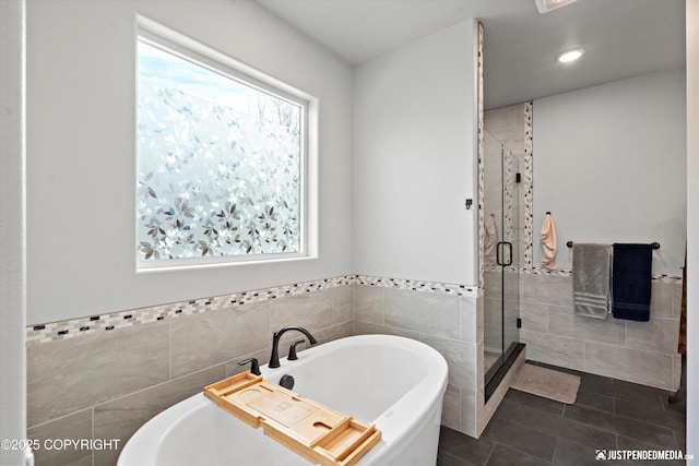 full bathroom with recessed lighting, tile walls, a freestanding bath, tile patterned floors, and a stall shower