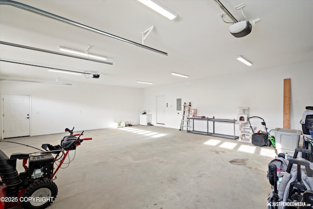 garage featuring washer / clothes dryer, electric panel, and a garage door opener