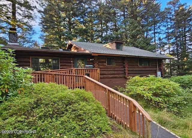 log home featuring log siding and a deck