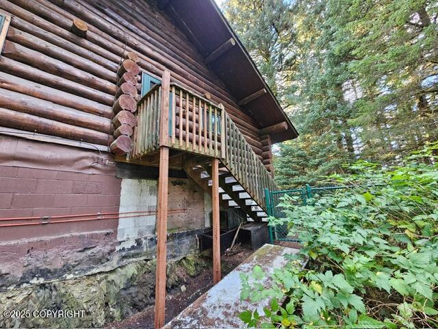 view of property exterior with stairway and log siding