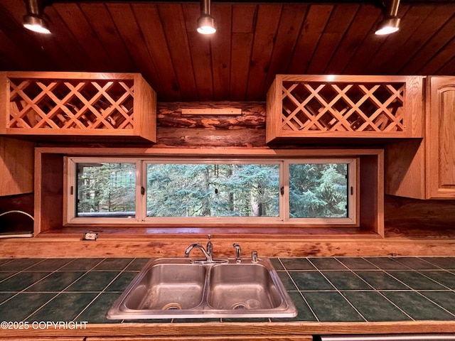 kitchen with wood ceiling, a sink, and tile countertops