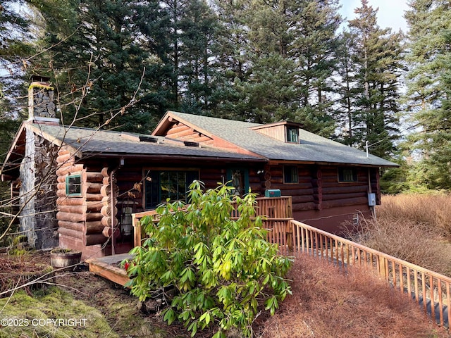 exterior space with a chimney and log siding