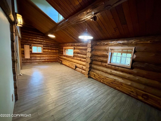 additional living space featuring lofted ceiling with skylight, wooden ceiling, wood finished floors, and log walls