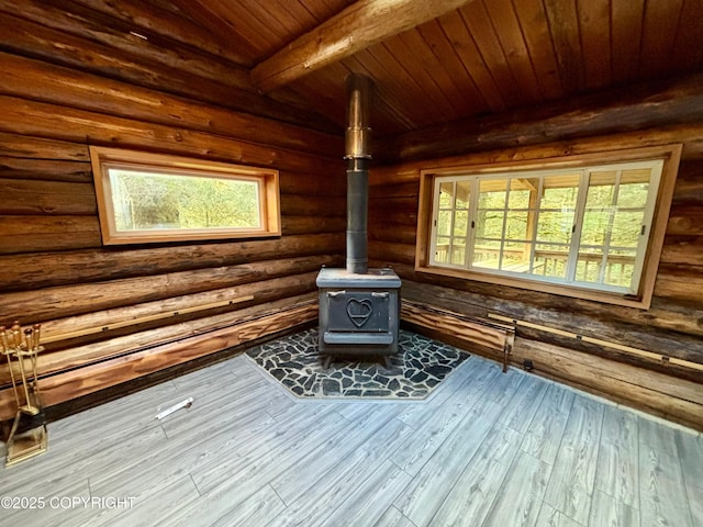 interior details featuring beam ceiling, log walls, a wood stove, wood finished floors, and wooden ceiling