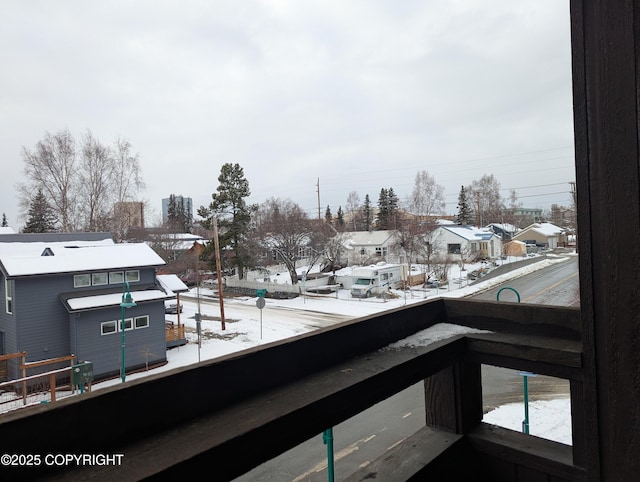 snow covered back of property with a residential view