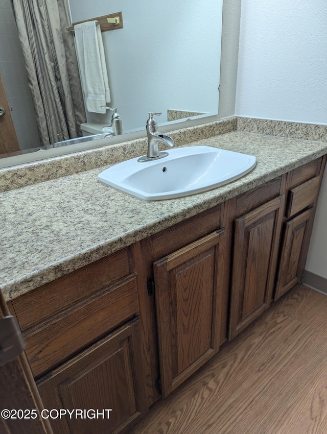 bathroom featuring vanity, curtained shower, and wood finished floors