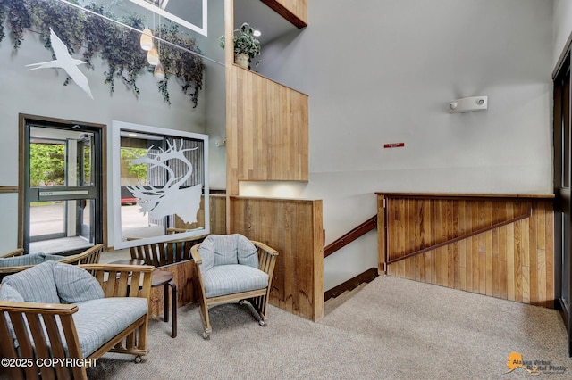 sitting room featuring carpet and a towering ceiling